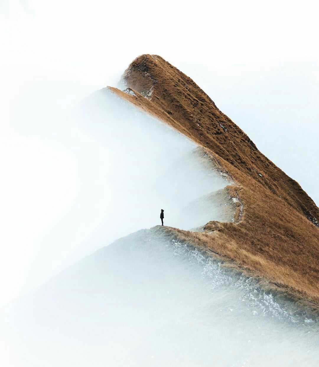A girl standing on a ridge in Switzerland.
