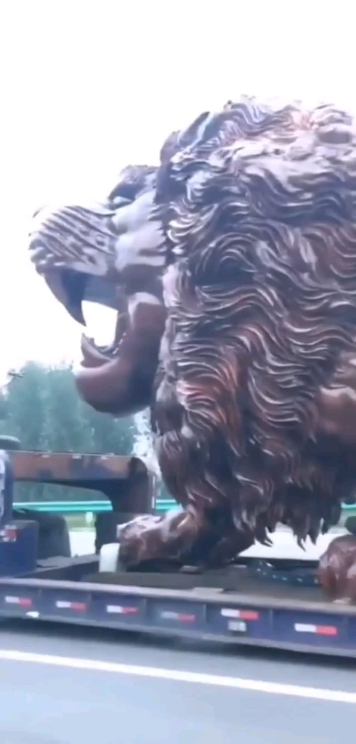 A lion carved out of wood speeding through the highway