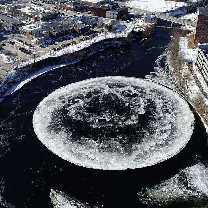 Huge spinning ice disc in river provides a carousel for ducks