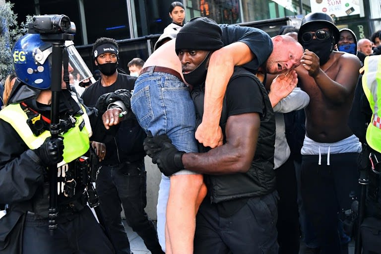 Black man carries suspected far-right protester to safety