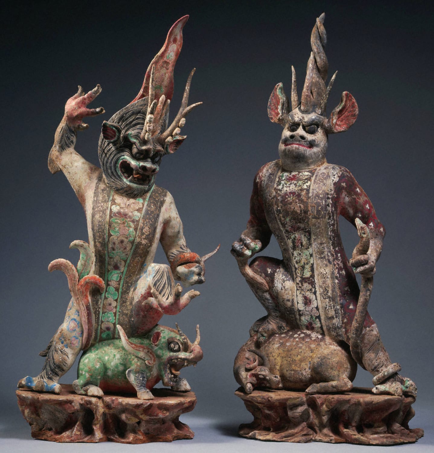 Two ceramic tomb guardians holding snakes. China, Tang dynasty, 8th century AD