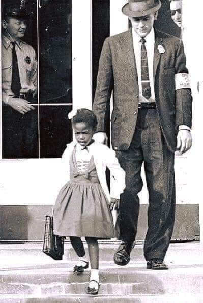 U.S. Marshalls escorting the extremely brave Ruby Bridges, 6 years old, to school in 1960. This Courageous young girl is known for being the first African American child to attend an all-white elementary school in the South.
