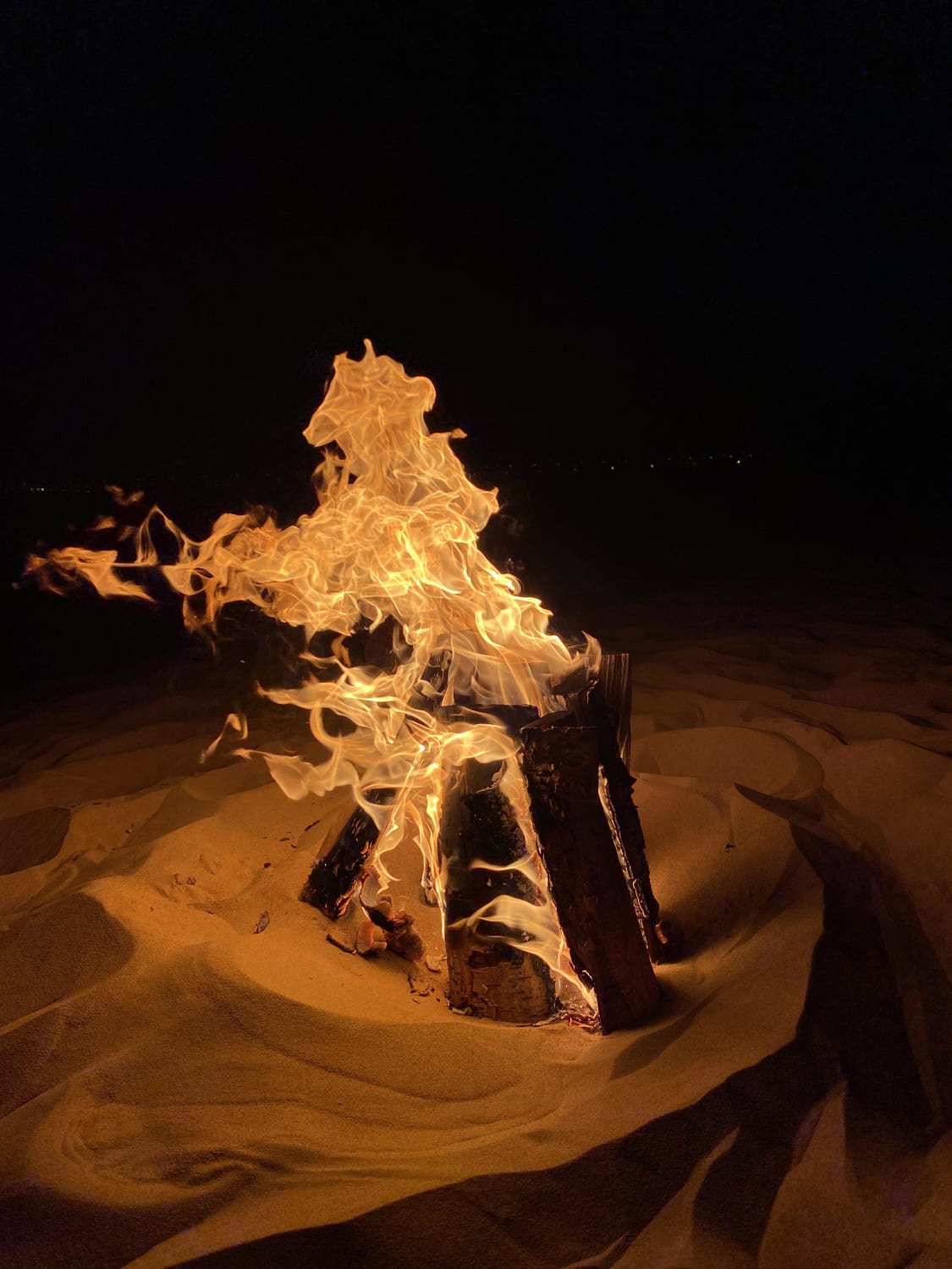 A shot of a campfire in Dubai desert, plus the fire seems to show a horse figure somehow
