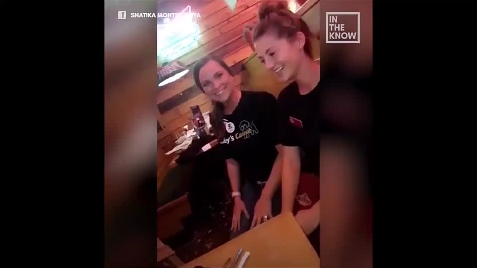 Two waitresses say 'Happy birthday' to a hearing-impaired four-year-old boy in sign language