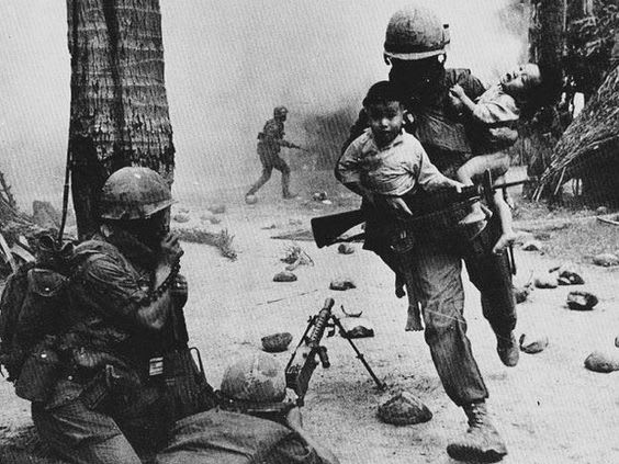 A U.S. Marine rescues two Vietnamese children during a gun battle at the city of Hue, during the Tet Offensive of the Vietnam War - 1968