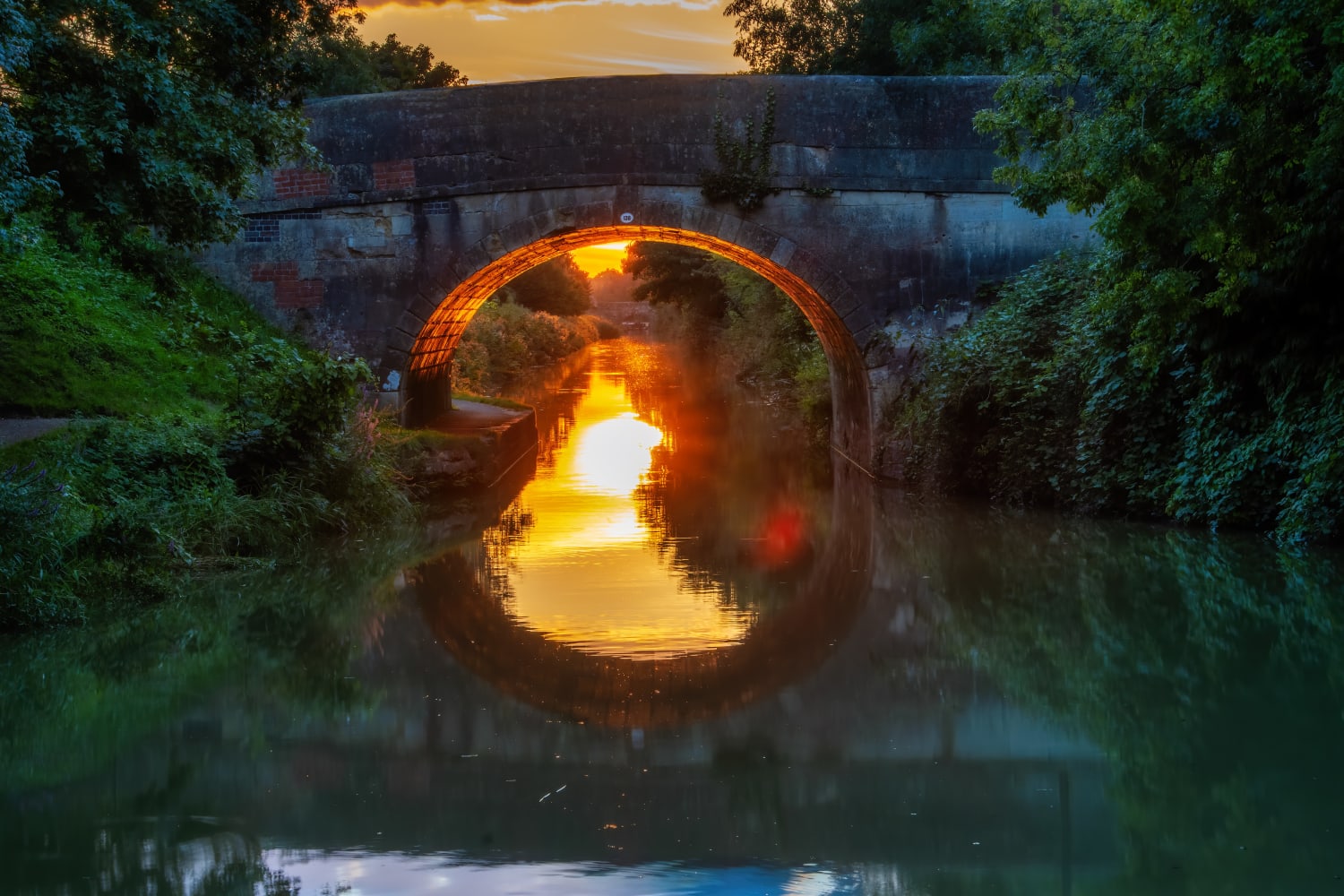 ITAP of a reflected sunset under a bridge.