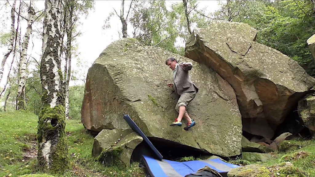 British Rock Climber Skillfully Scales Small Boulder Without Using His Hands While Dressed in Tweed