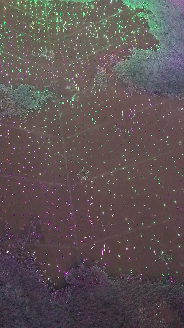 Puddle reflecting lights which look like mini fireworks when rain drops into it