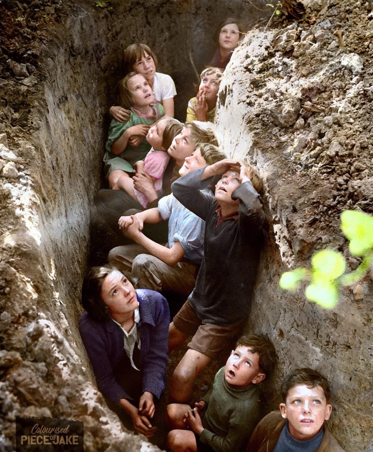 Children from London, hiding in a trench in Kent, watching German planes overhead, during the battle of Britain. 📷 John Topham (1940).