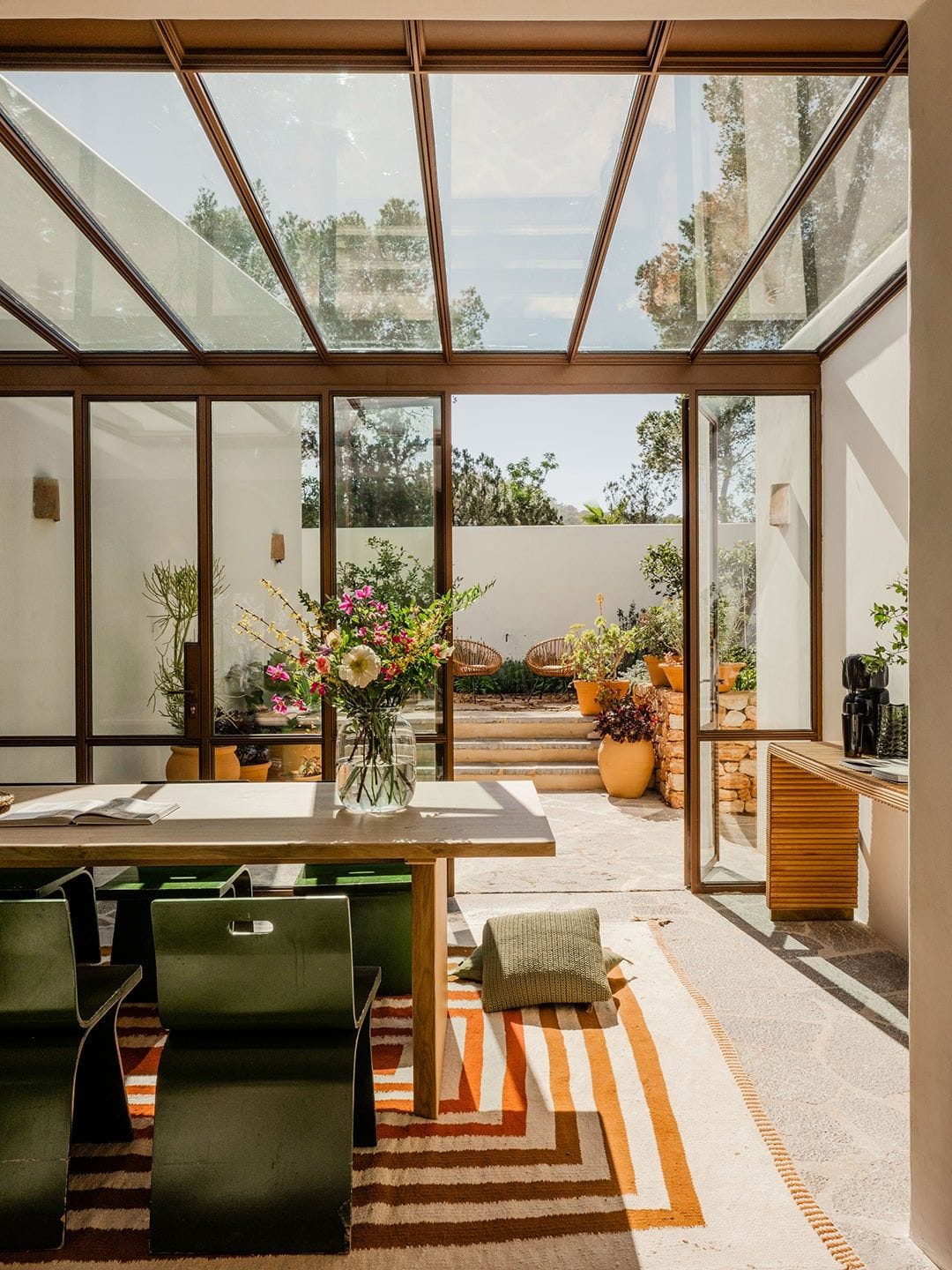 Glass-enclosed dining room in a renovated 1970s vacation retreat ...