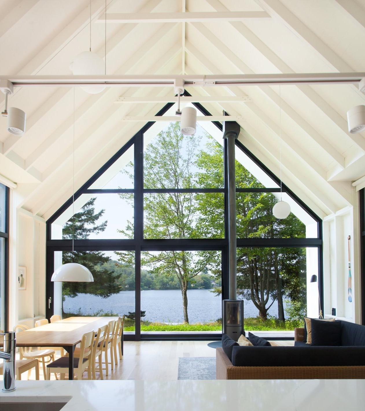 Great room with double-height ceiling opening up to views of Lac Plaisant, Saint-Élie-de-Caxton, Canada by YH2