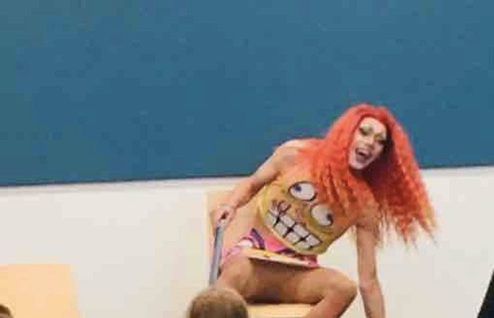 Photo shows Drag Queen Story Hour performer in miniskirt exposing crotch as children sit close by
