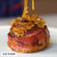 This bunless bacon-wrapped burger topped with onions is a meat lover's delight.