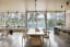 Kitchen and dining space with floor-to-ceiling glass walls offering views of the Sakinaw Lake, Sunshine Coast, British Columbia, Canada