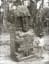 An old photo, taken by Alfred Percival Maudslay in 1894, of a man standing next to Stela K, a Maya stone monument carved in 805 CE and located near the eastern border of the Great Plaza in Quiriguá, Guatemala
