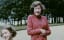 Fun behind the formalities: Princess Elizabeth gives the camera the biggest smile she could muster in a still image from a home video. Princess Margaret playfully curtsies almost out of frame.