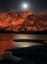 The moon rising over a hill in California that is engulfed in a wildfire looks really eerie.
