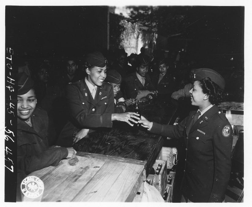 2nd Lt. le Beau serves the first Coca Cola to Major Adams, at the grand opening of the battalion's new snack bar, OTD in 1945. The 6888th Central Postal Directory Battalion was the only African American women’s unit to serve overseas in World War II.