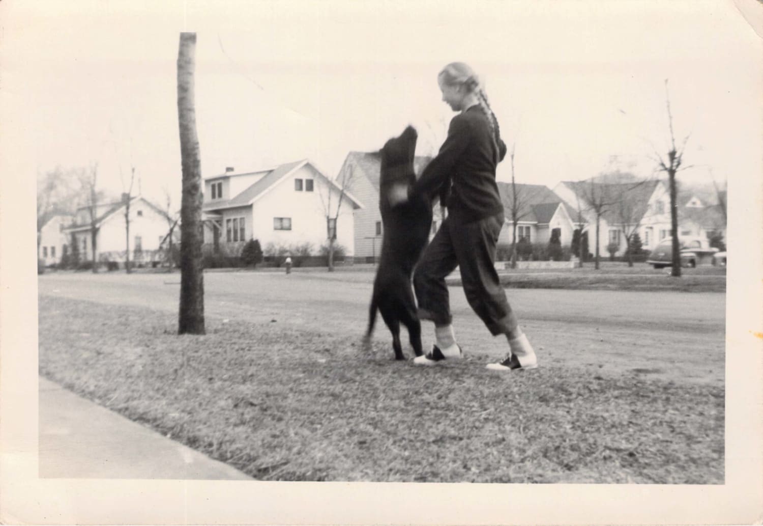 Girl dances with her dog - undated snapshot, 1940s