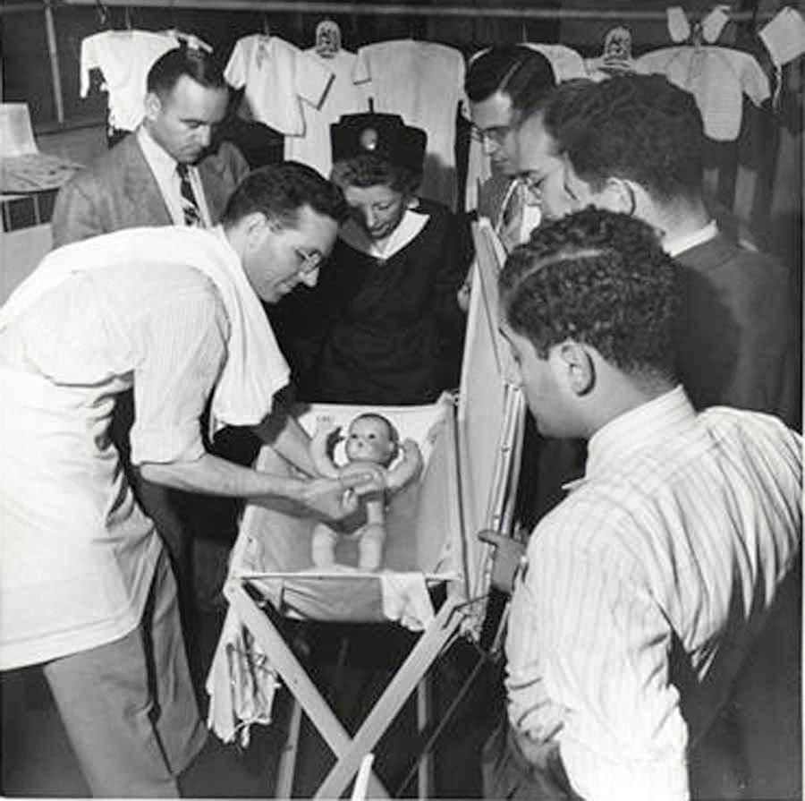 Men at a fathering class practice bathing the baby, June 1948. Photo: Hazel Kingsbury.