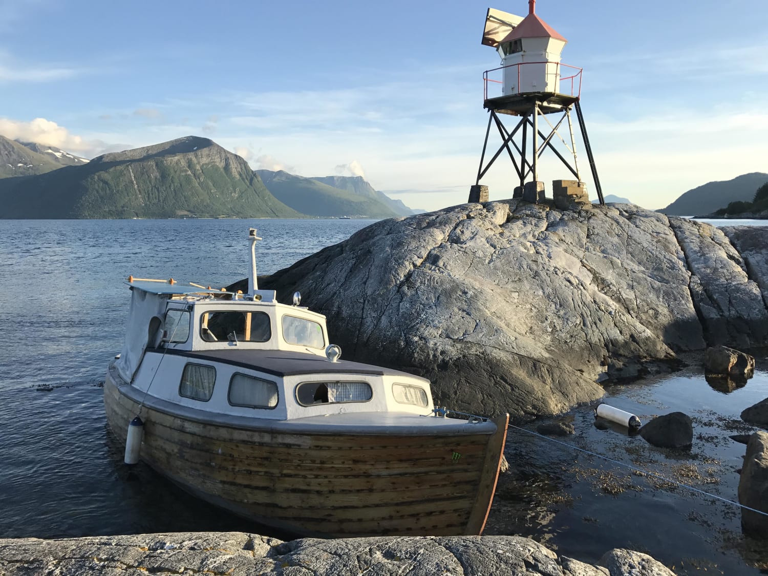 Abandoned boat by lighthouse