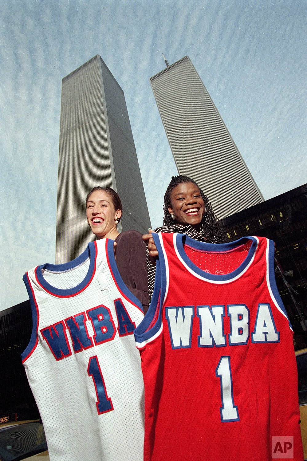 The @WNBA season begins tonight. Olympic gold medalists Rebecca Lobo, left, and Sheryl Swoopes display their jerseys for the inaugural season of the Women's National Basketball Association in the shadow of New York's World Trade Center, in this Oct. 23, 1996 photo.