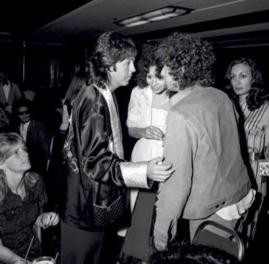 Paul talking to Bob Dylan at a Wings album launch party. Long Beach, California. 1975. (Image - Harry Benson).