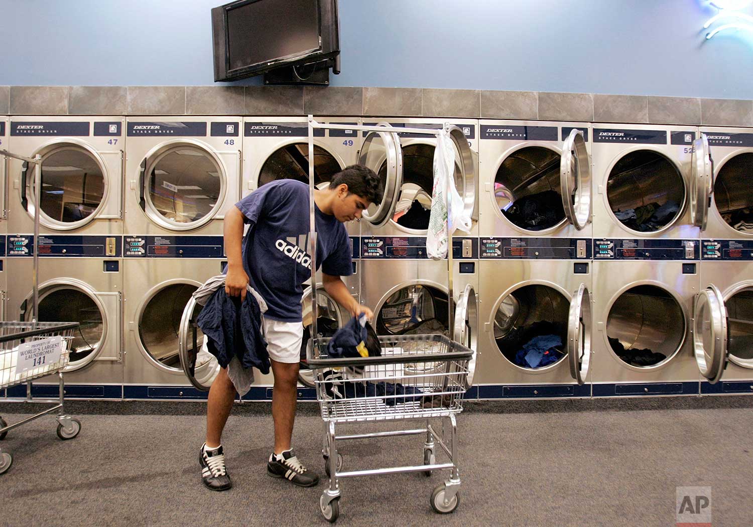 OTD in 1934, the first laundromat (called a "washateria") opened in Fort Worth, Texas. Giovanni Marron does his laundry at the "World's Largest Laundromat" in Berwyn, Ill., Wednesday, July 26, 2006. | Photo Brian Kersey