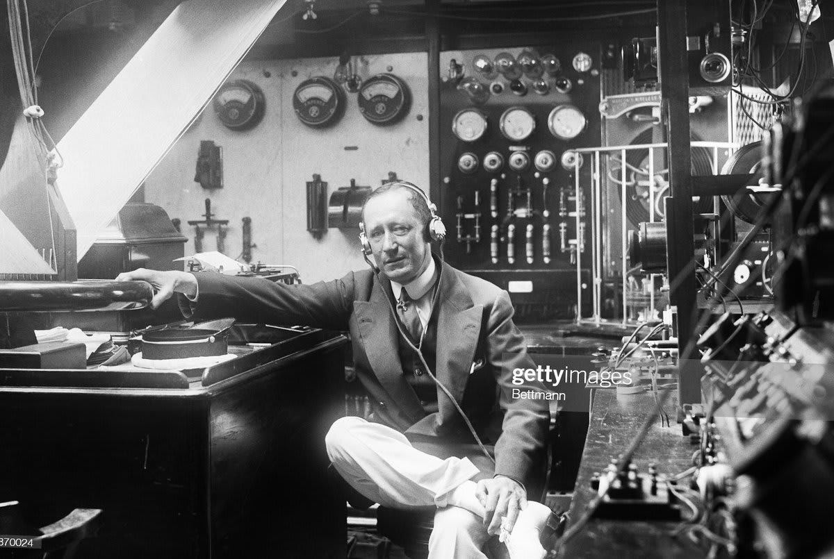 Guglielmo Marconi, inventor of the radio, in his office. He is currently trying to listen to conversations on the planet Mars. He is also an active Senator of Italy.