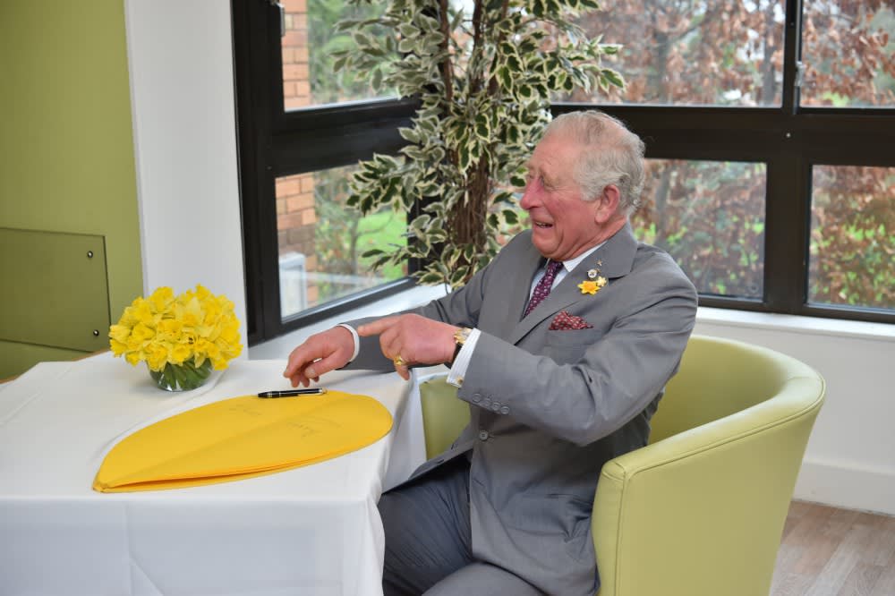 The Prince of Wales signs a petal as part of the Great Daffodil Appeal during a visit to the Marie Curie Hospice in Cardiff and the Vale, Wales Photo by: Ben Birchall/PA Wire