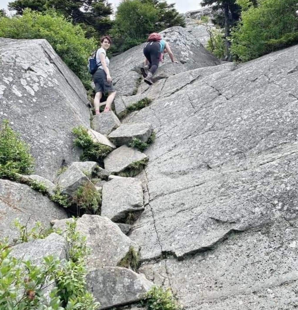 Going up some steep rocks on Mt Monadnock, New Hampshire, USA