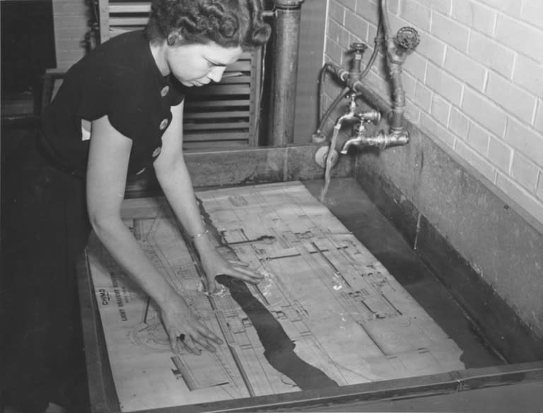 When photographer Jackie Martin came to the National Archives Building in 1946 to get images for a future photo story, she photographed staff members working on the preservation of damaged engineering drawings of the USS Chimo’s “Motive Engine.”