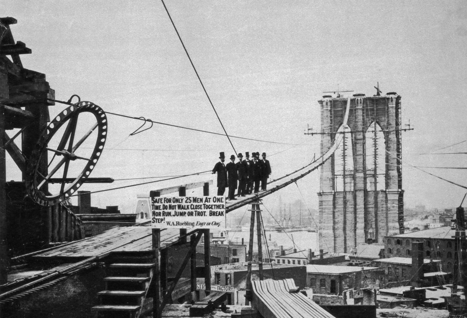 1875: Men pose for a photo on a temporary catwalk during the construction of the Brooklyn Bridge.