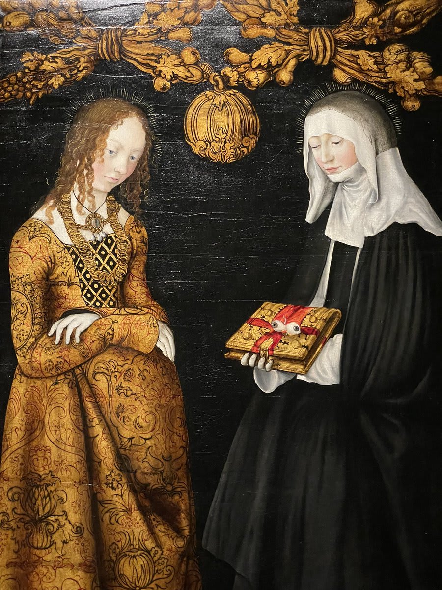 Saints Christina and Ottilia. Ottilia holds a rather striking pair of eyeballs - recalling how her baptism cured her blindness. Part of an altarpiece for the Electors of Saxony by Lucas Cranach the Elder (@NationalGallery)