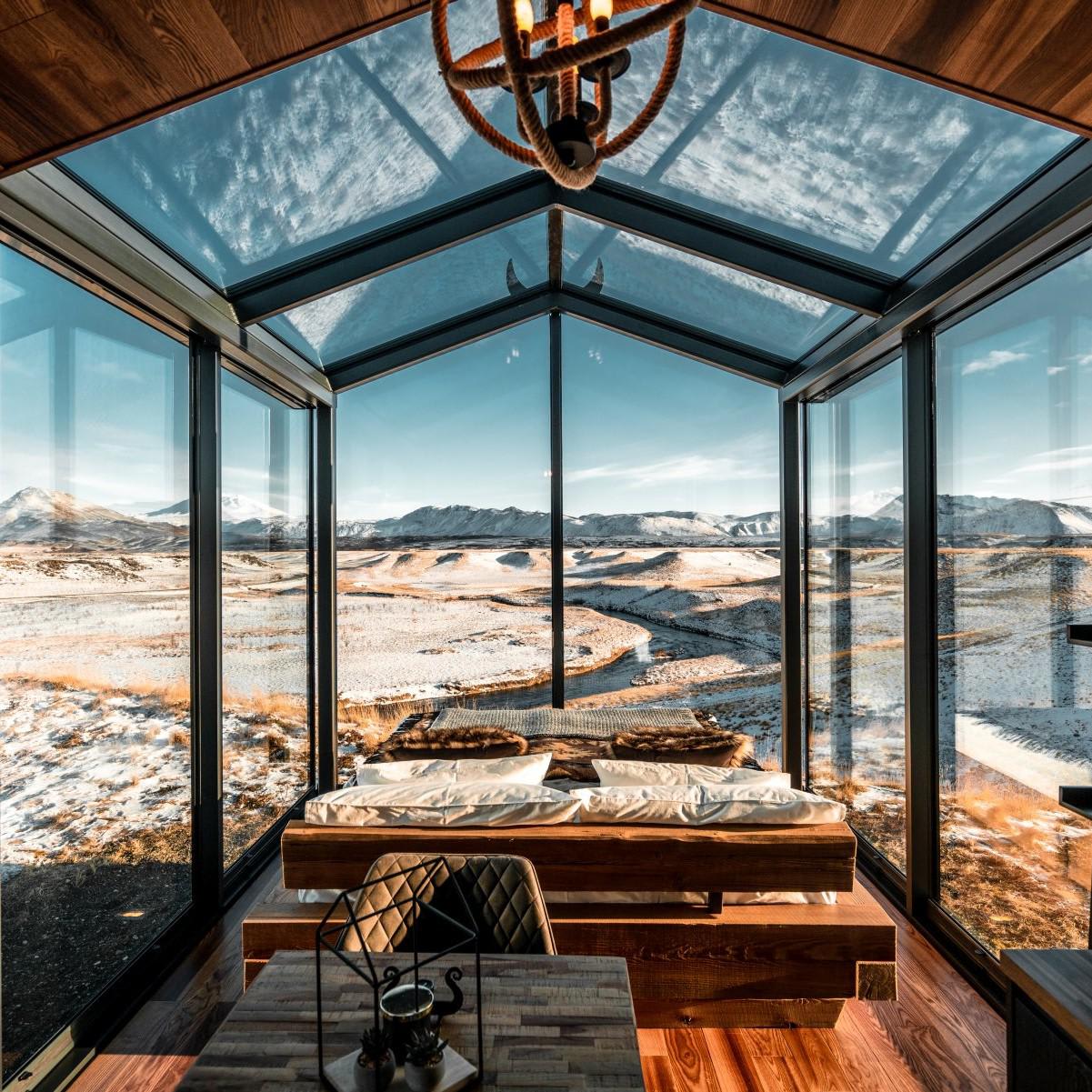 Bedroom inside a glass cabin with panoramic views of Iceland countryside, by ÖÖD (Photo: Panorama Glass Lodge)