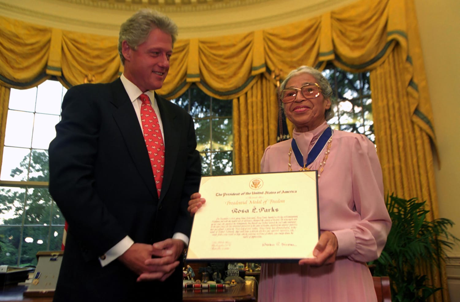 President Bill Clinton presents civil rights icon, Rosa Parks with the Presidential Medal of Freedom certificate in the Oval Office. 1996