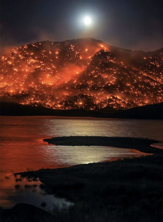Moon rising over burning California hills, in Lake Isabella [by Michael Cuffe]