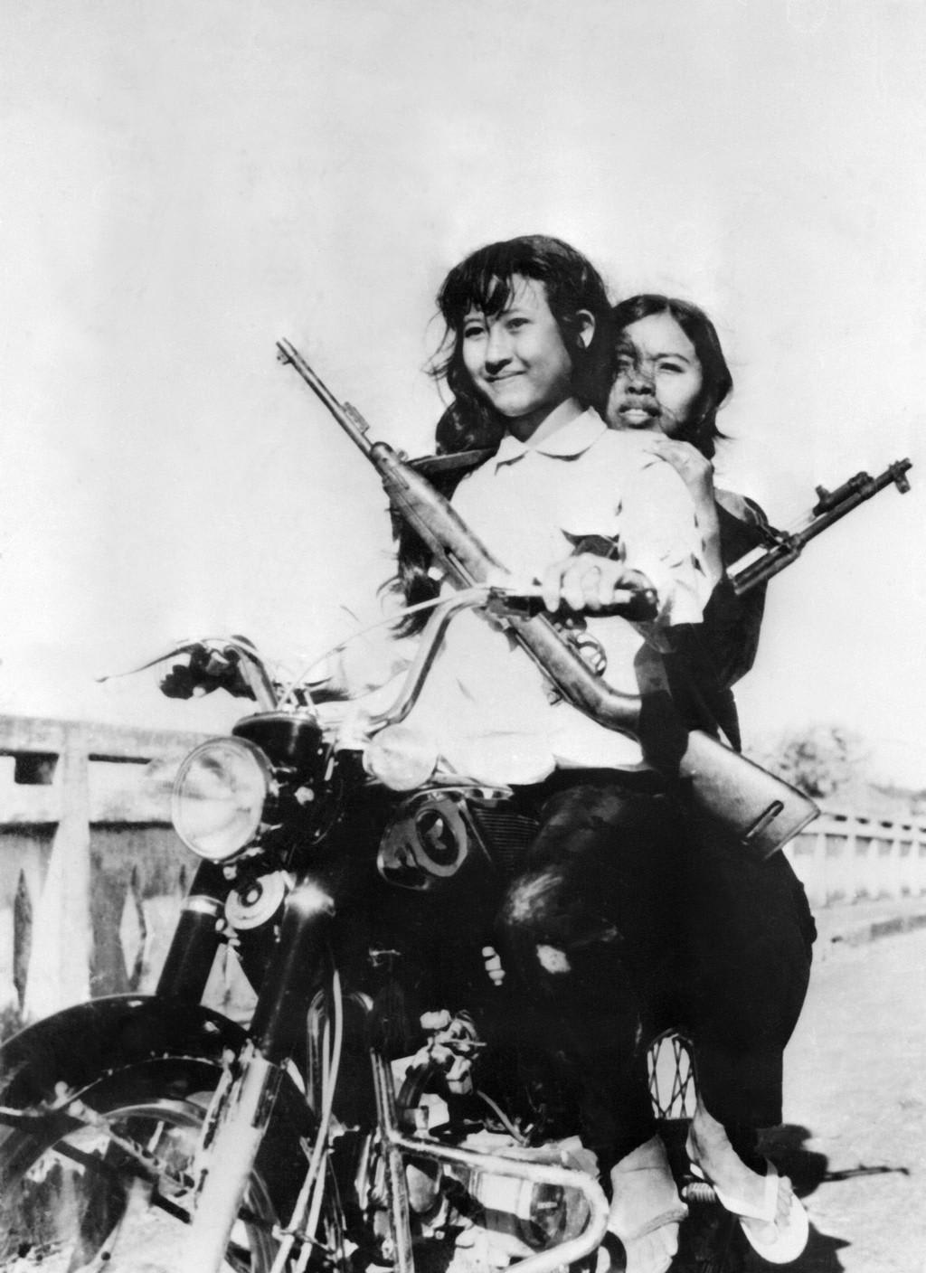 The faces of evil: Two Khmer Rouge teenage cadres riding down the street of Phnom Penh, April 1975