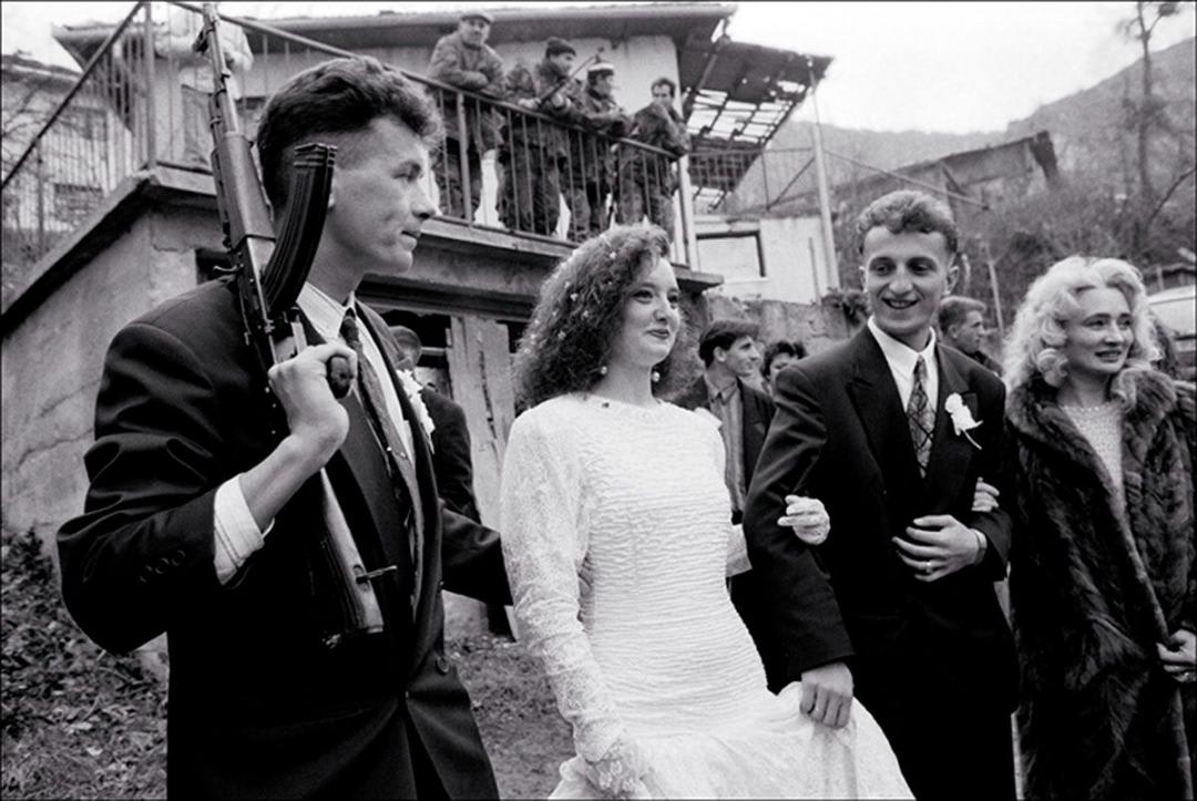 “Amidst civil war, a Bosnian Muslim bride and groom celebrate their wedding day as traditionally as possible while they are being protected by an armed groomsman”; captured by David Turnley (1995)