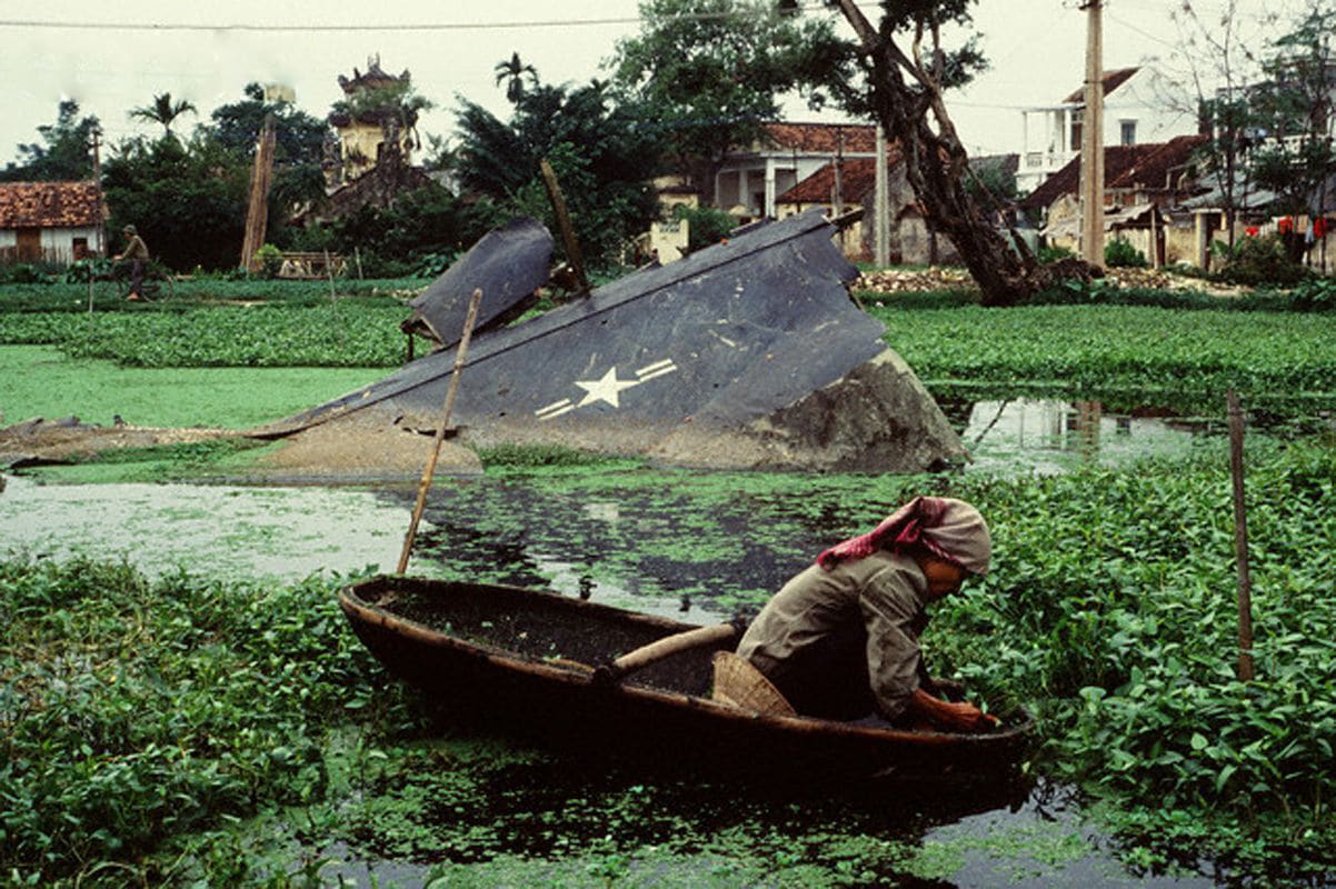 Vietnamese farmer with the B52 Stratofortress wreckage in the background, somewhere in the 80s