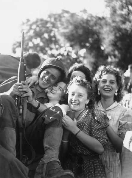 GI surrounded by joyous locals during the liberation of Paris, August 25, 1944.