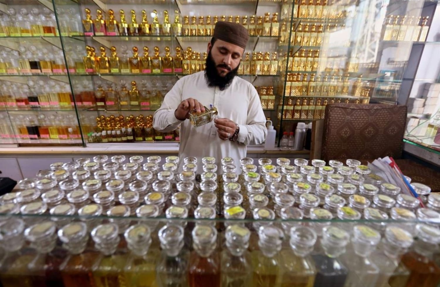 Vendor selling non-alcoholic perfumes during Ramadan in Peshawar, Pakistan. (Image - EPA).