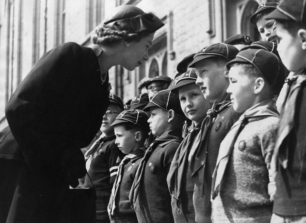 Queen Elizabeth II talking to young Cub Scouts at Windsor Castle, her first public engagement following a period of Court Mourning after the death of King George VI. 26th April 1953.