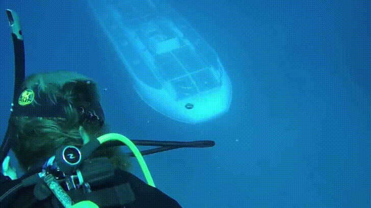 Submarine passing below some Hawaiian scuba divers