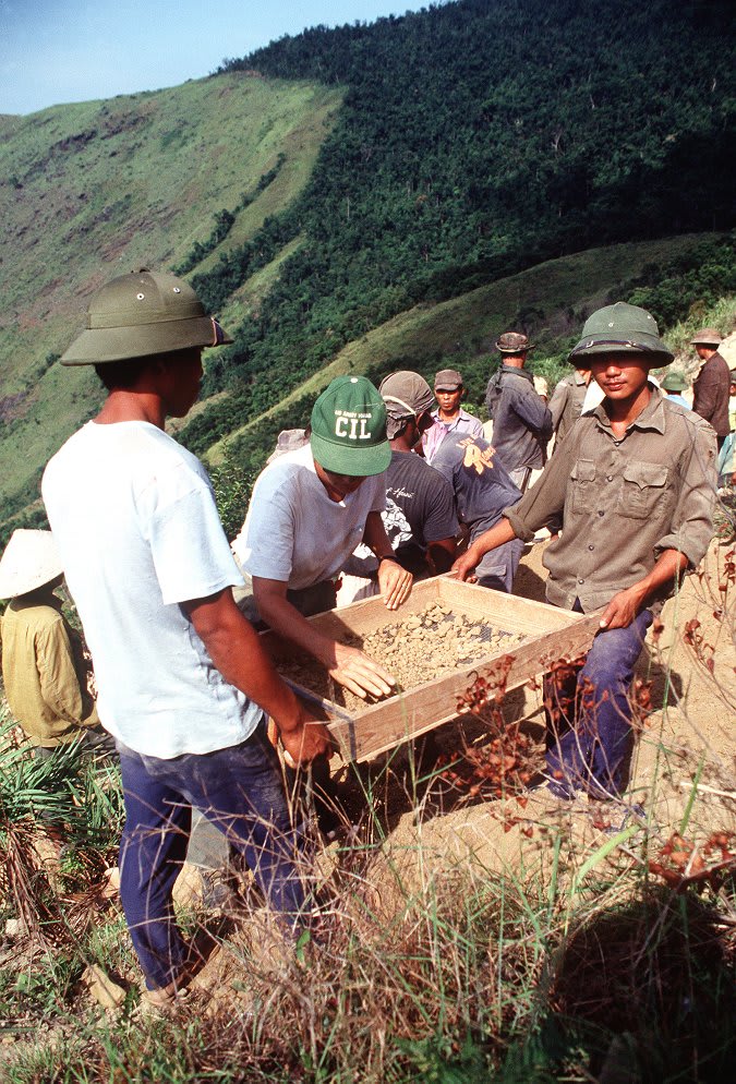 Members of a joint U.S./Vietnamese anthropological team sift through ground and stones in an effort to locate personal effects of an American pilot whose aircraft crashed at this site during the war in Vietnam. OTD in 1991