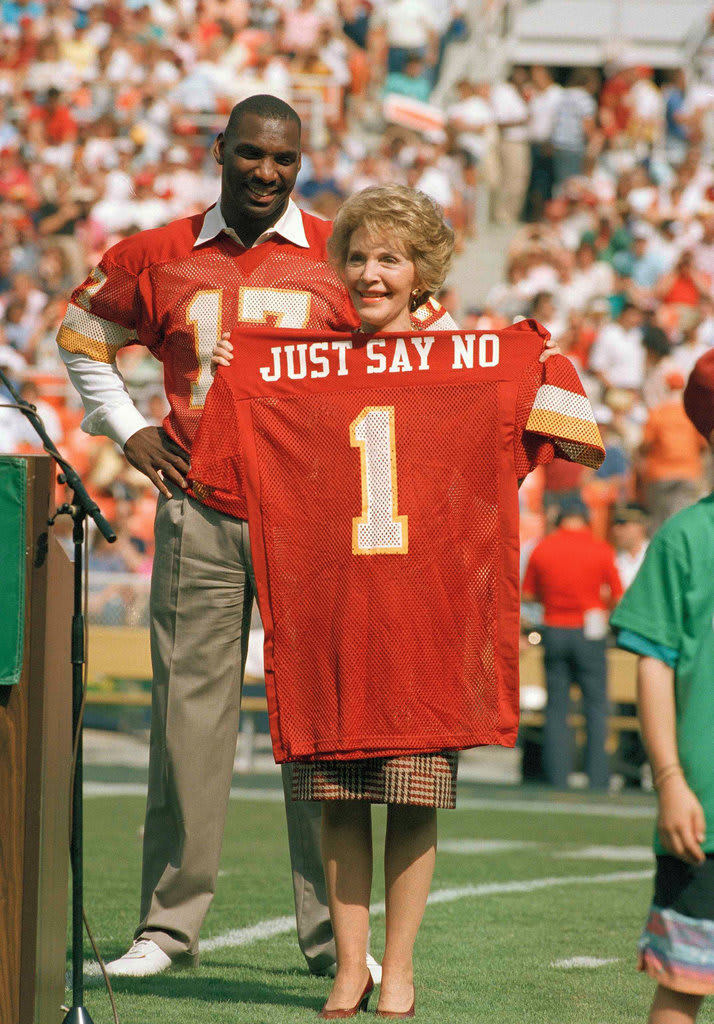 Nancy Reagan, First Lady of the United States, holds up a jersey emblazoned with her famous anti-drug slogan "Just say no". RFK Stadium, Washington D.C., 1988.
