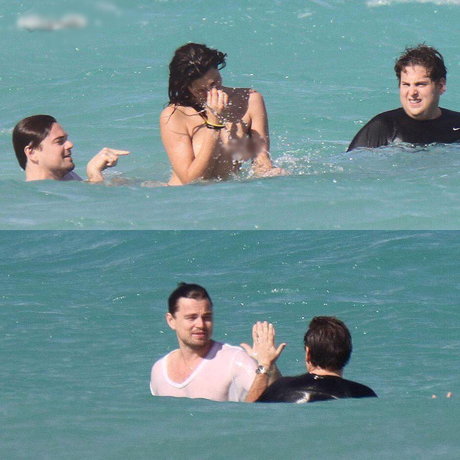 Leo DiCaprio and Jonah Hill share a high-five after swimming with a topless woman in Miami.
