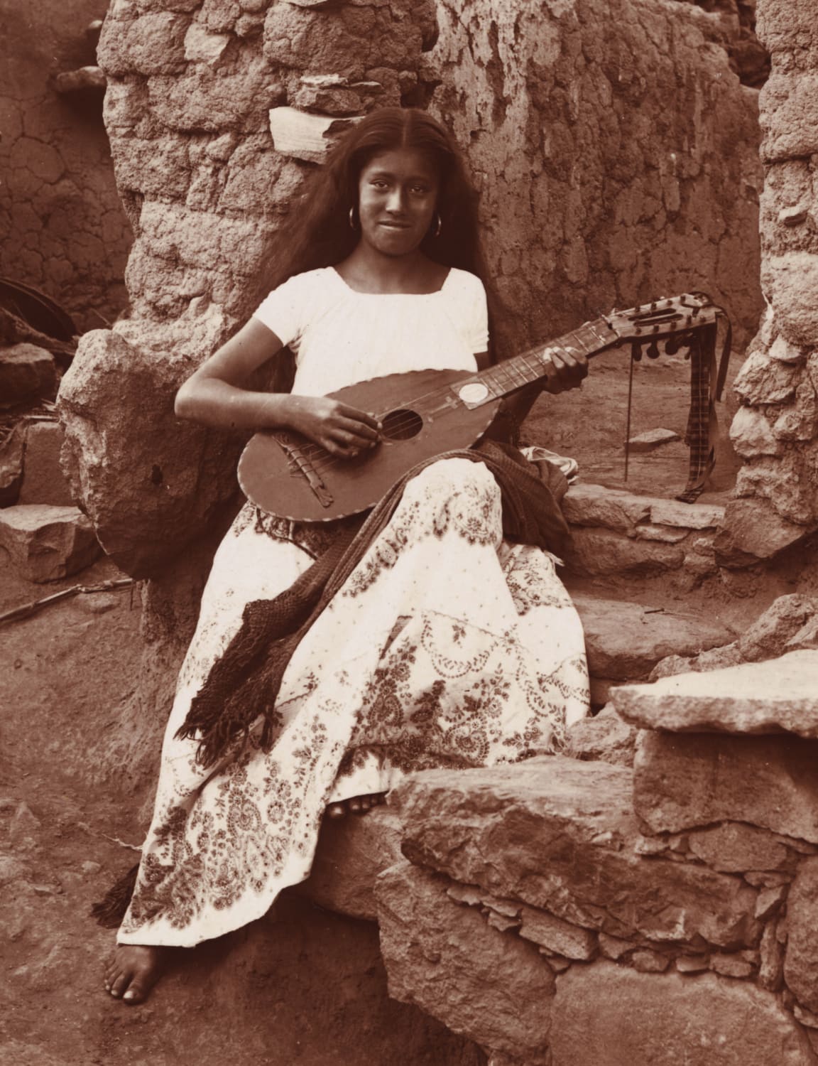 Young Woman from Guanajuato, Mexico playing a mandolina conchera, a guitar-like instrument traditionally made from the shell of an armadillo circa 1895