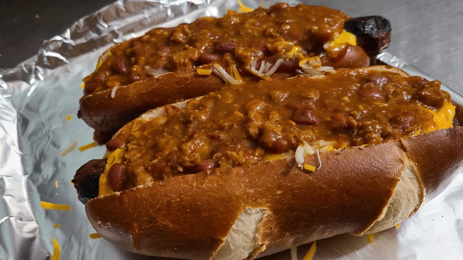 [Homemade] Baked pretzel bun chilli cheese dogs.