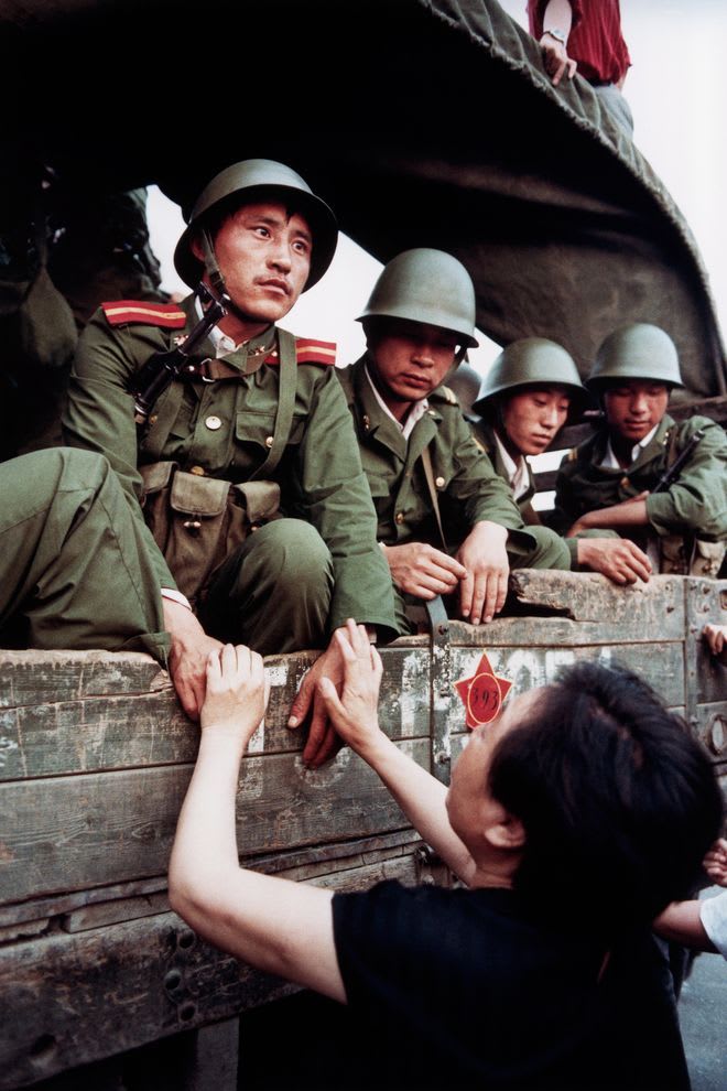 David Turnley, As thousands of Chinese troops rolled into the heart of Beijing, the mother of one of the students begs a young soldier to put down his arms, Tiananmen Square, June 3, 1989. .